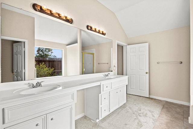 bathroom featuring a sink, lofted ceiling, a shower stall, and double vanity