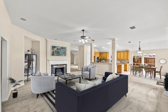 living room with visible vents, ornate columns, a high end fireplace, ceiling fan, and light carpet