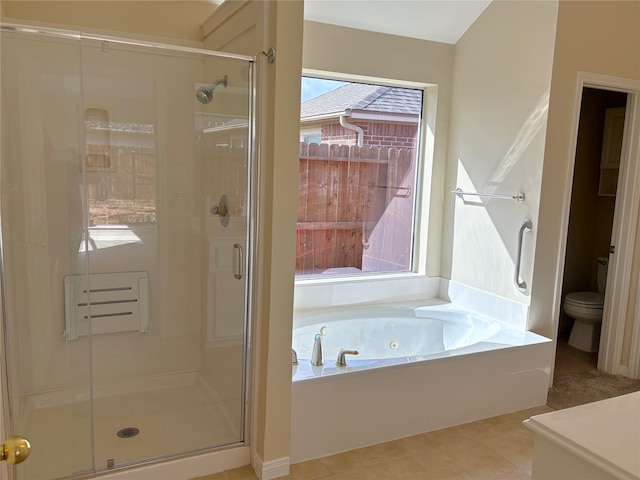 bathroom with toilet, a jetted tub, a shower stall, and tile patterned flooring