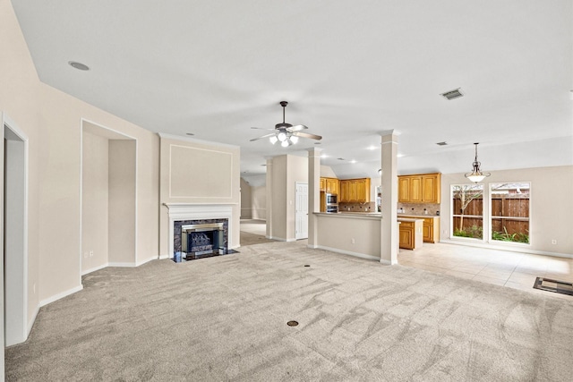 unfurnished living room featuring a premium fireplace, light colored carpet, ceiling fan, and vaulted ceiling