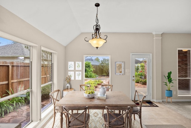 dining room featuring vaulted ceiling, light tile patterned floors, baseboards, and decorative columns