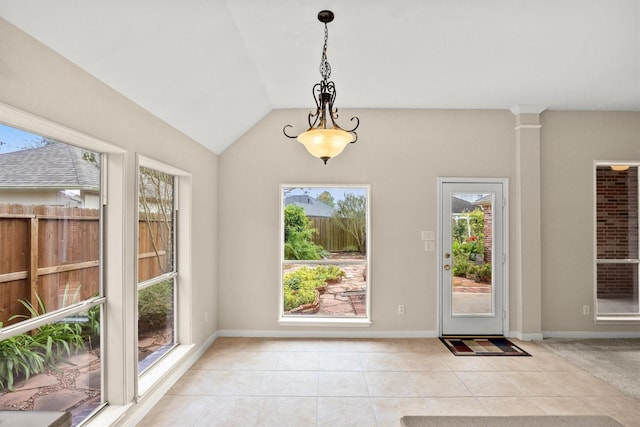 doorway with lofted ceiling, light tile patterned floors, and baseboards