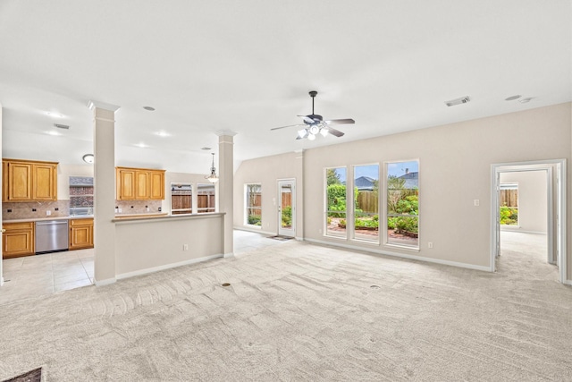 unfurnished living room with visible vents, baseboards, light colored carpet, ceiling fan, and ornate columns