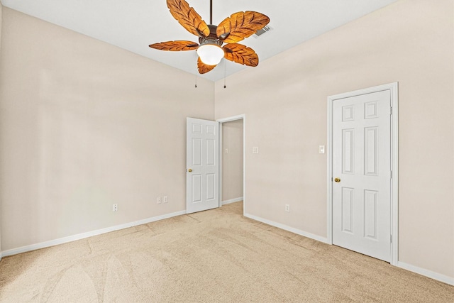 empty room featuring baseboards, light colored carpet, and ceiling fan