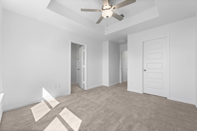 11837 E Gate Dr, Willis, TX 77318 - unfurnished bedroom with visible vents, baseboards, carpet, and a tray ceiling