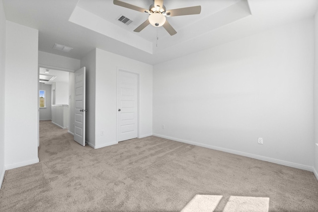 11837 E Gate Dr, Willis, TX 77318 - unfurnished bedroom with visible vents, baseboards, a tray ceiling, carpet flooring, and a ceiling fan