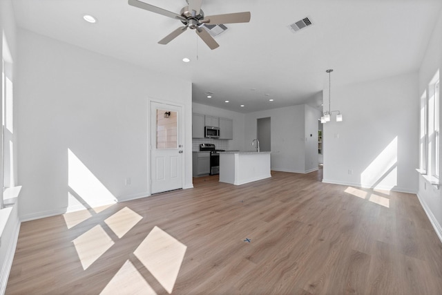 11837 E Gate Dr, Willis, TX 77318 - unfurnished living room with light wood-type flooring, visible vents, and recessed lighting