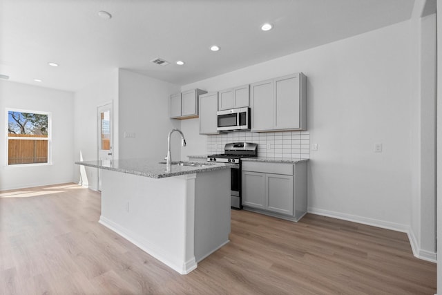 11837 E Gate Dr, Willis, TX 77318 - kitchen featuring tasteful backsplash, gray cabinets, appliances with stainless steel finishes, and a sink