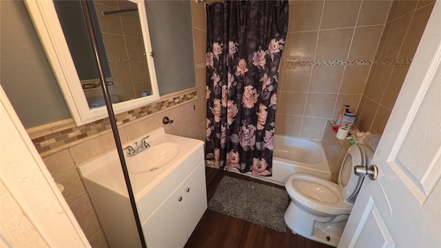 bathroom featuring vanity, wood finished floors, shower / bath combination with curtain, tile walls, and toilet