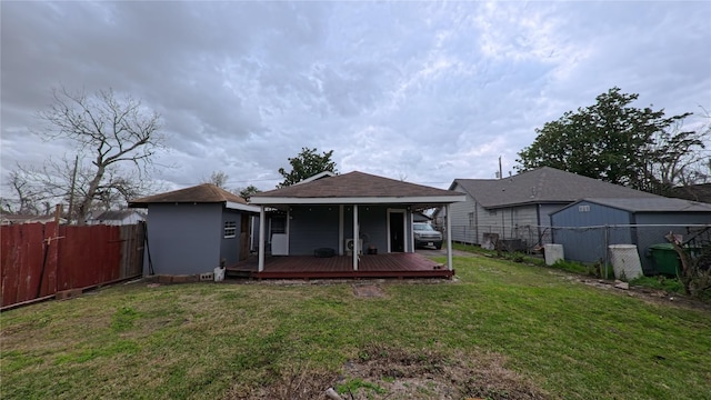 back of property featuring an outdoor structure, a yard, and a fenced backyard