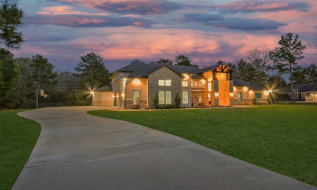 contemporary house featuring stone siding, an attached garage, concrete driveway, and a front lawn