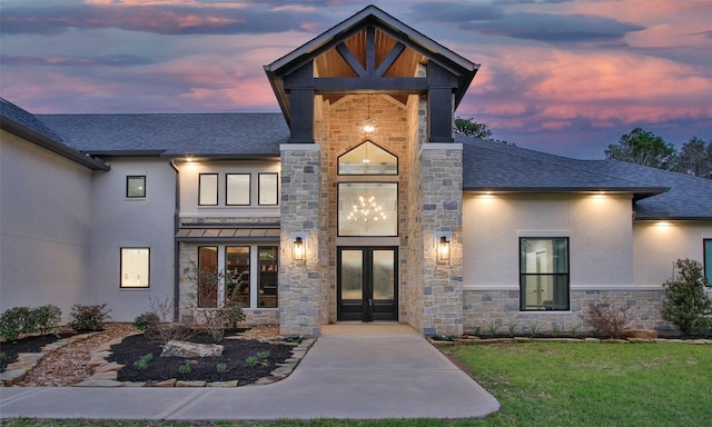 entrance to property featuring roof with shingles, stucco siding, french doors, metal roof, and stone siding