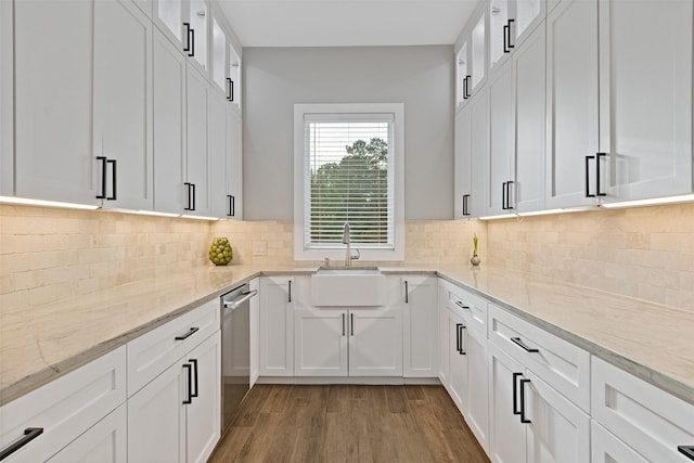 kitchen featuring a sink, light wood-style flooring, white cabinets, and decorative backsplash