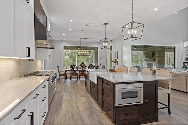 kitchen featuring a kitchen bar, stainless steel range, dark brown cabinets, and white cabinetry