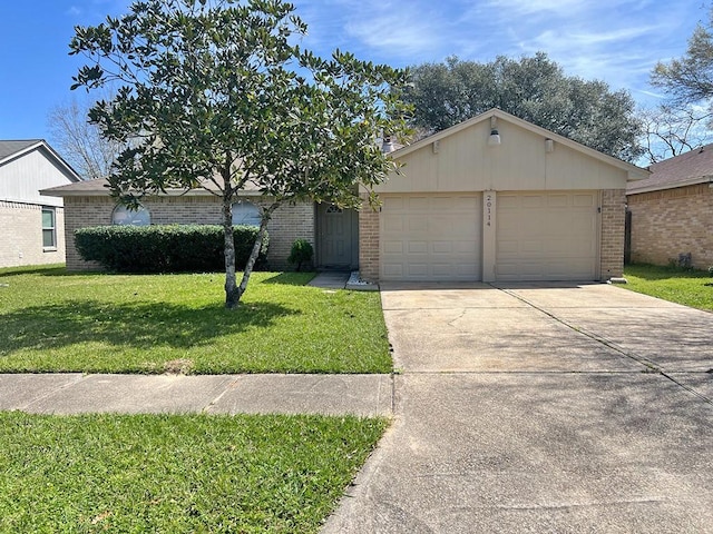 view of front of house featuring brick siding, an attached garage, concrete driveway, and a front yard