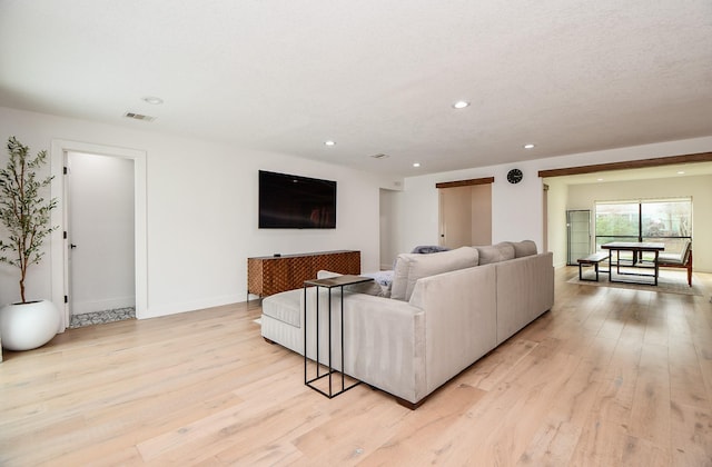 living area featuring light wood finished floors, visible vents, and recessed lighting