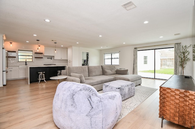 living area featuring visible vents, recessed lighting, and light wood-type flooring