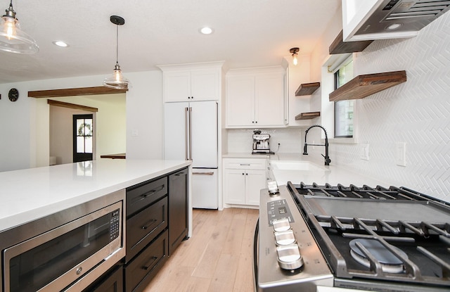 kitchen featuring open shelves, a sink, stainless steel appliances, light countertops, and white cabinets