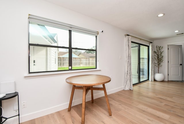 living area with a wealth of natural light, baseboards, light wood-style flooring, and recessed lighting