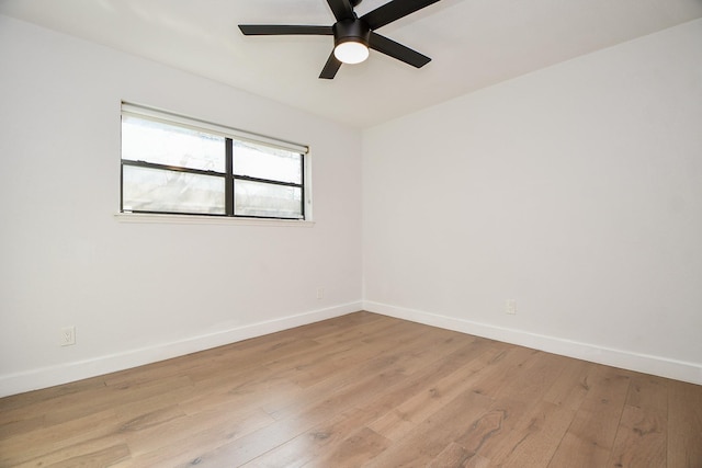 empty room featuring light wood-style flooring, a ceiling fan, and baseboards