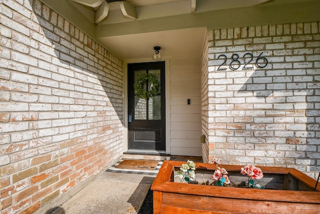 property entrance featuring brick siding