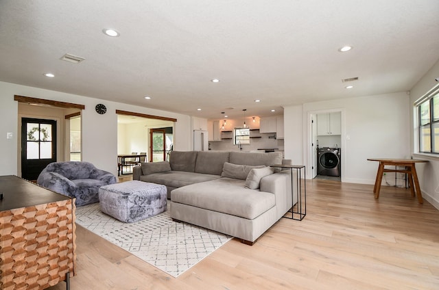 living area featuring light wood finished floors, visible vents, recessed lighting, and washer / clothes dryer