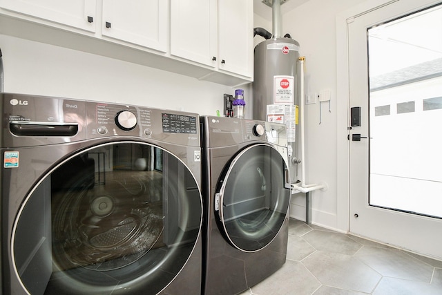 washroom with cabinet space, light tile patterned floors, washer and dryer, and water heater