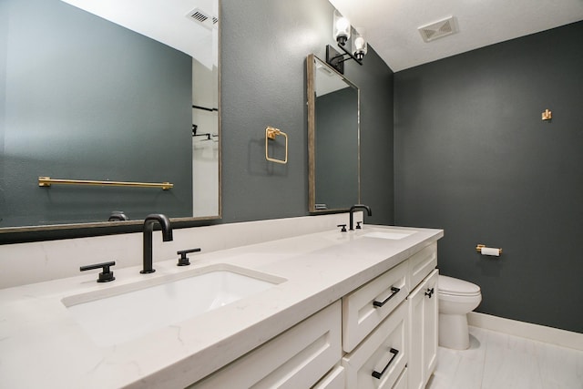 bathroom with toilet, visible vents, and a sink