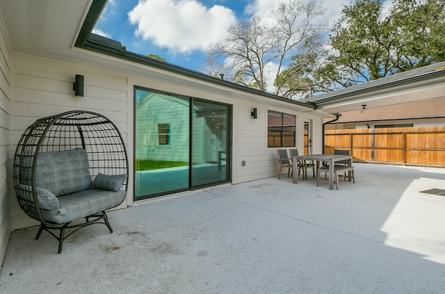 view of patio featuring outdoor dining space and fence