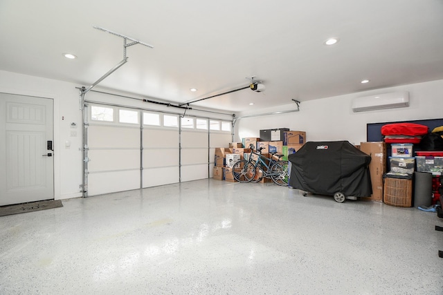 garage with a wall mounted air conditioner and a garage door opener