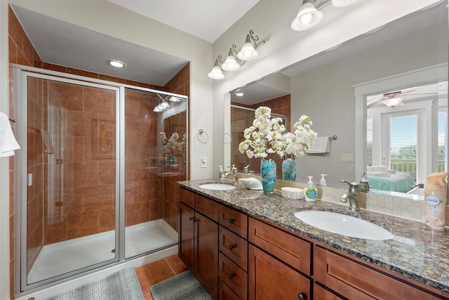26501 Mangrove Dr Unit 203, Galveston, TX 77554 - ensuite bathroom featuring double vanity, a stall shower, tile patterned floors, and a ceiling fan