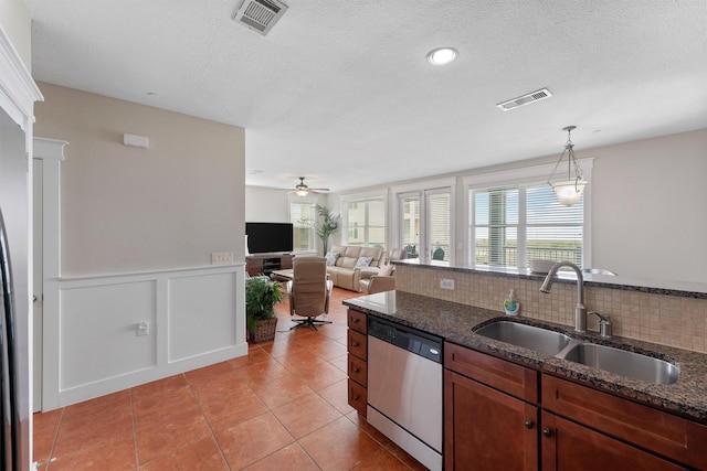 26501 Mangrove Dr Unit 203, Galveston, TX 77554 - kitchen featuring stainless steel dishwasher, hanging light fixtures, light tile patterned flooring, a ceiling fan, and dark stone counters