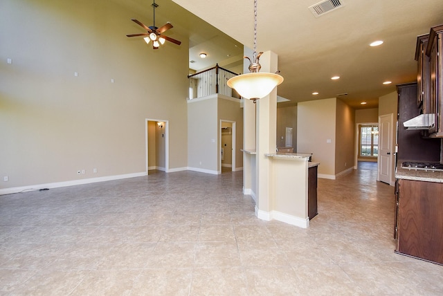 kitchen with visible vents, light stone countertops, open floor plan, recessed lighting, and a ceiling fan