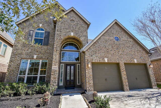 traditional-style house with brick siding, concrete driveway, and a garage
