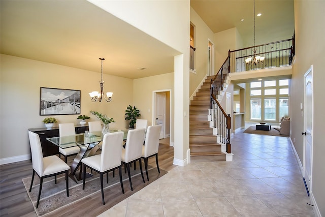 dining area with stairs, an inviting chandelier, baseboards, and tile patterned floors
