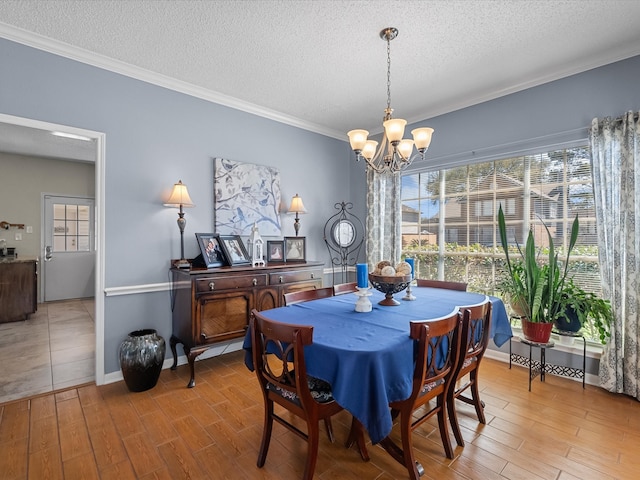 dining area featuring crown molding, baseboards, light wood-style flooring, an inviting chandelier, and a textured ceiling