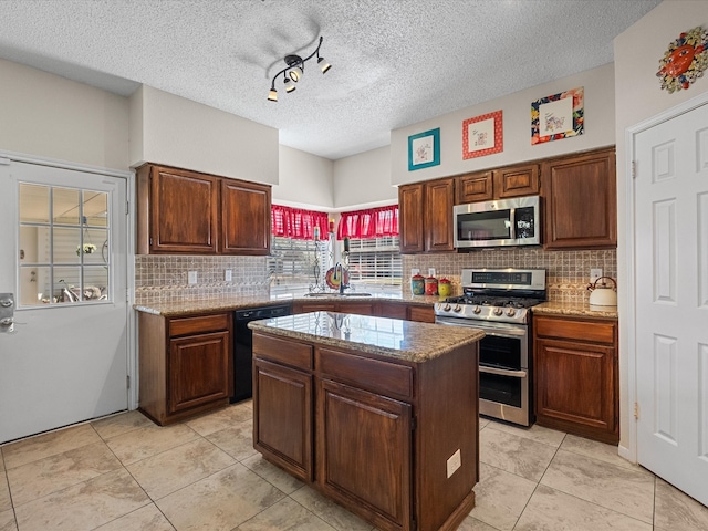 kitchen featuring a sink, backsplash, appliances with stainless steel finishes, and a center island