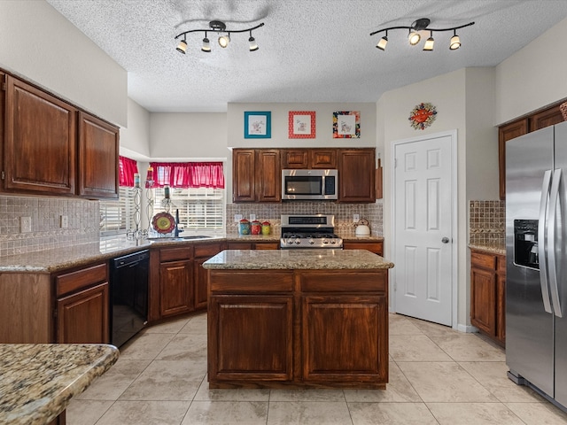 kitchen featuring light tile patterned floors, stainless steel appliances, backsplash, and a center island