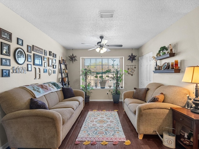 living room with a ceiling fan, baseboards, wood finished floors, visible vents, and a textured ceiling