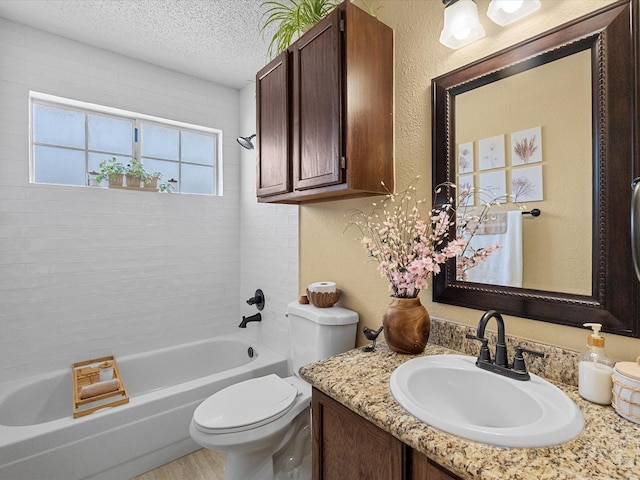 bathroom with bathing tub / shower combination, toilet, a textured wall, and a textured ceiling