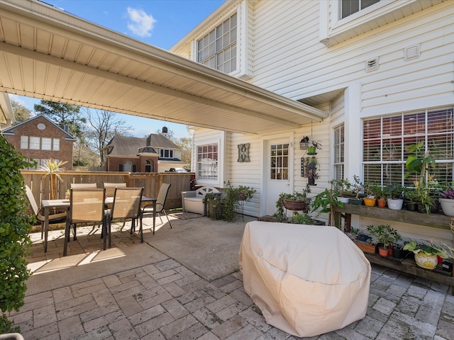 view of patio with outdoor dining area and fence