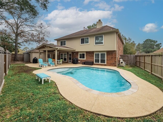 view of swimming pool with a fenced backyard, a fenced in pool, a lawn, and a patio