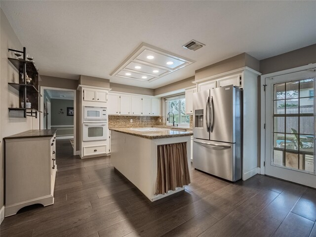 kitchen featuring white cabinetry, white appliances, tasteful backsplash, and visible vents