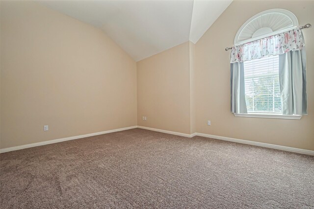 unfurnished room with vaulted ceiling, baseboards, and carpet floors