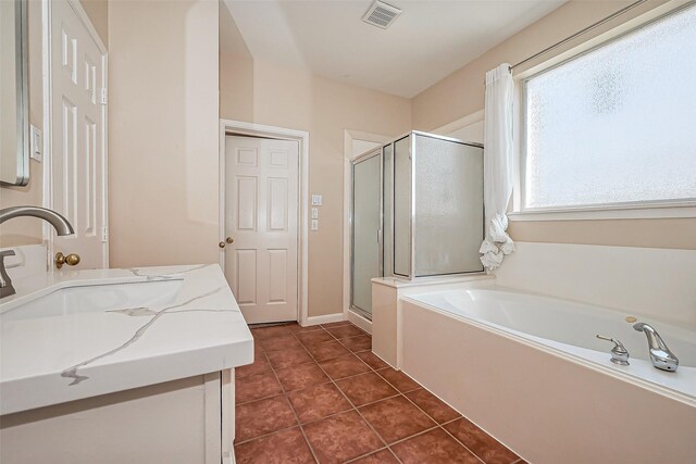 bathroom featuring tile patterned flooring, visible vents, a stall shower, a bath, and vanity