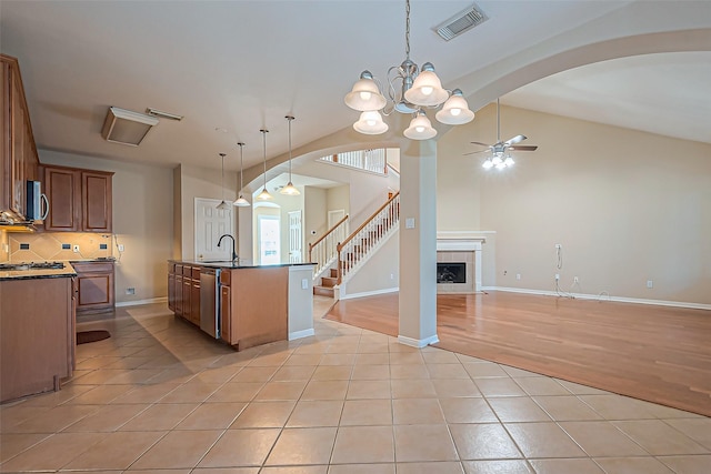 kitchen with visible vents, open floor plan, stainless steel appliances, arched walkways, and light tile patterned flooring