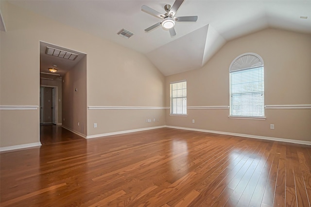 unfurnished room featuring visible vents, lofted ceiling, a ceiling fan, and hardwood / wood-style flooring