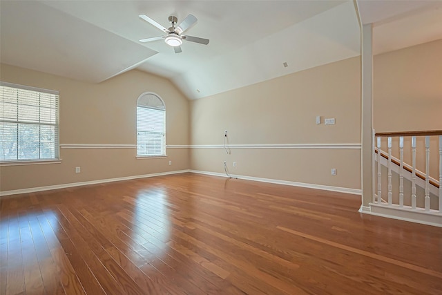 empty room with vaulted ceiling, wood finished floors, baseboards, and ceiling fan