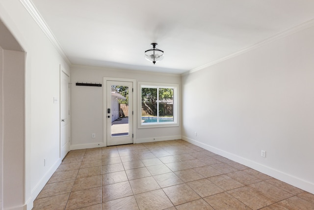 spare room featuring baseboards, ornamental molding, and light tile patterned flooring