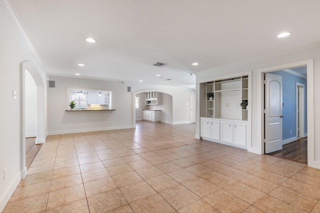 unfurnished living room featuring visible vents, ornamental molding, recessed lighting, light tile patterned flooring, and arched walkways